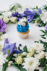spring cupcake on a white background with flowers and fruits aro