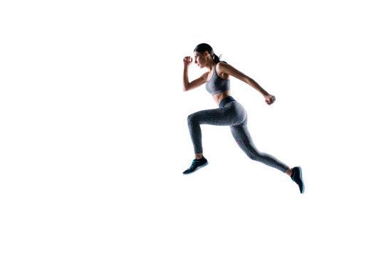 Ready steady go! Concept of endurance strength persistence in sport. Full length full size portrait of beautiful sporty energetic active purposeful sportswoman running and jumping, natural light
