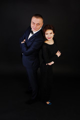 Elegance woman in black evening dress with man in suit posed on studio isolated on black. Duet couple of two.
