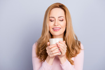 Close up portrait of charming nice good-looking lovely cute peaceful attractive woman holding white mug of tea cacao isolated on gray background