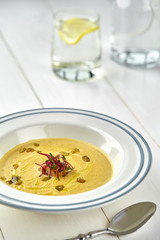 Healthy dinner with pumpkin soup-puree served in white bowl