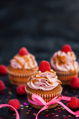 Raspberry and caramel cupcakes on dark background