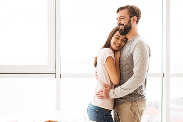 Naklejka premium Smiling young couple embracing while standing