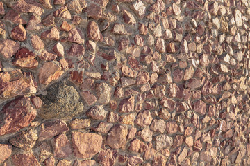 masonry of the old wall of rough cut red stone