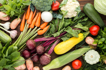 fresh vegetables: beet, carrot, zucchini, broccoli and others on wooden background, top view