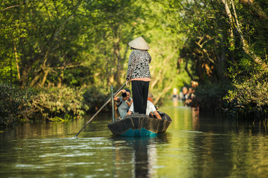 A woman rowing a boat with tourists aboard