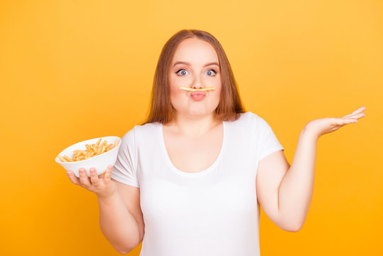 Young woman balancing french fry on her lips