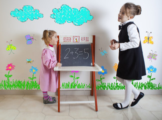 Little girl teaching mathematics to a younger child