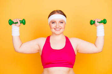 Young woman flexes arms with hand weights