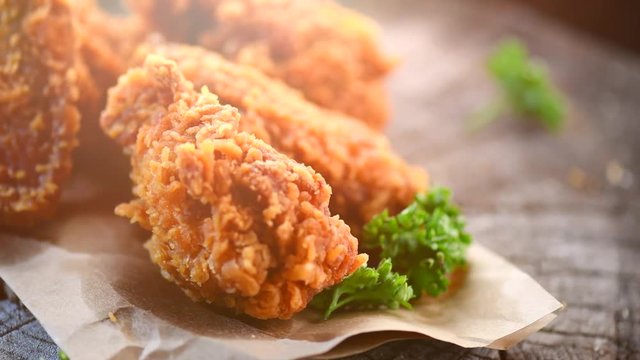 Chicken. Rotation crispy fried chicken on a wooden table. 4K video footage. Ultra high definition 3840X2160
