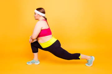 Fototapeta na wymiar Young woman in exercise clothes doing lunge exercise