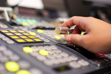 Hands on  dissolve of Switcher buttons in studio TV station, Audio and Video Production Switcher of Television Broadcast.