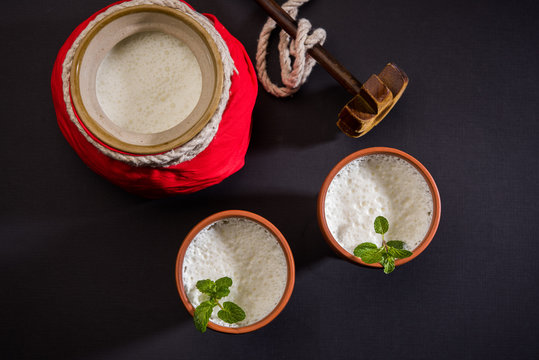 Lassie or lassi in terracotta glass - Lassi is an Authentic Indian cold drink made up of curd and milk and sugar, selective focus
