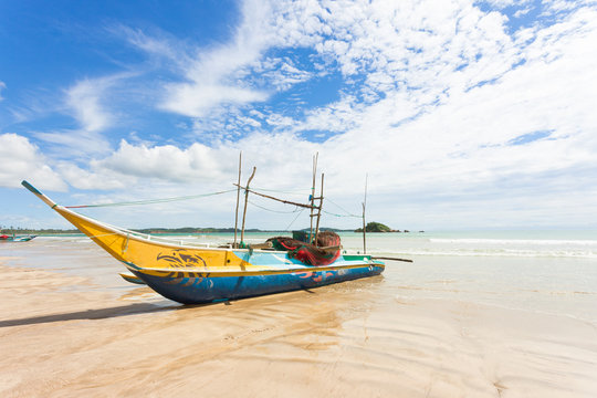 Weligama Beach, Sri Lanka - A traditional fishing boat at the sandy beach of Weligama