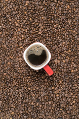 Naklejka premium red mug on the background of scattered coffee beans