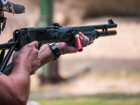 male aim and shooting shotgun to target in shotgun shooting competition