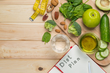 Diet plan concept - selection of green food and note pad