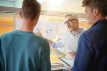 Teacher in classroom teaching economics to young people