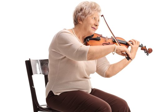 Elderly woman seated on a chair playing a violin