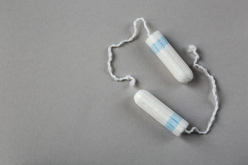 Means of protection of female hygiene. Hygienic tampons on a gray background. Organic gaskets made of bio-cotton. Menstrual cycle.