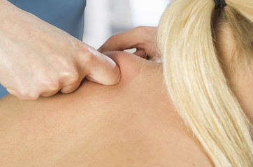 Chiropractor, physiotherapist examining her patient back and doing decontracting massage. Osteopathy