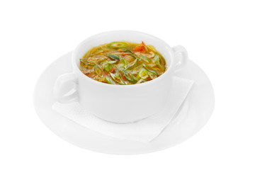 Transparent soup, with vegetables, noodles, fuchozoj, greens, onions, pepper, chicken. On a napkin in a white plate isolated white. Serving dishes in a cafe, restaurant, for a menu. Side view