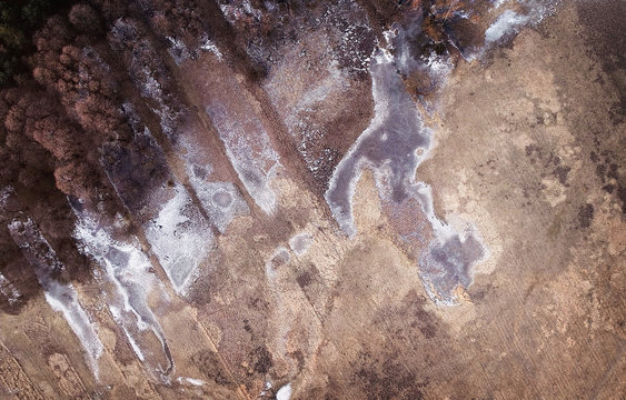 Winter landscape from drone - forest and frozen water on fields