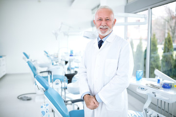 Smiling, happy and satisfied dentist at the clinic