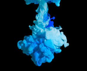 White and blue color paint in water on a black background