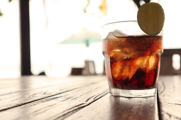 Cola in Glass on the Beach Table, with Blurred Background