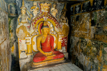 Meditation of Buddha statue with guards in ancient fresco walls of 14th century temple in Sri Lanka