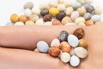 Nude woman body parts and  multicolored hand painted Easter eggs.