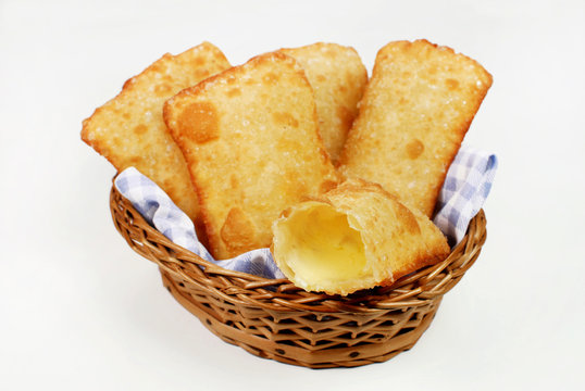 Fototapeta Brazilian typical pastry called pastel in white background with one of cheese open