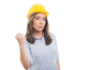 Portrait of female constructor showing fist looking mad.