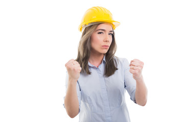 Portrait of female constructor showing fists like fighting.
