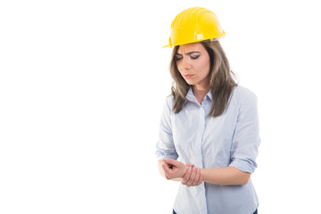 Portrait of female constructor holding her wrist.