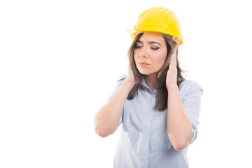 Portrait of female constructor covering her ears.
