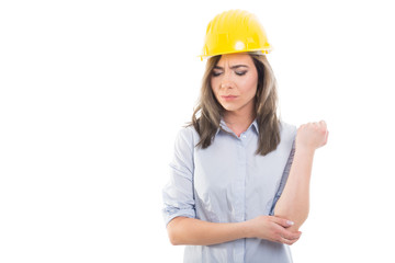 Portrait of female constructor holding her elbow.