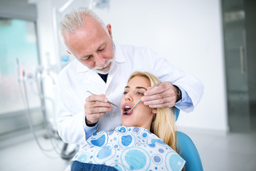 Experienced senior dentist  reviews patient  teeth