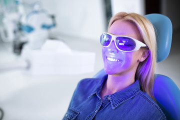 A young woman on the treatment of teeth whitening