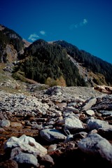 Obraz premium Bergbach Gebirgsbach mit Wasser und Steinen blauer Himmel