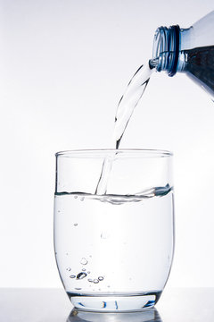 Bottle of water pouring water into a glass

