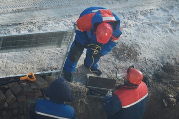 Working men in the form of standing around a sand pit