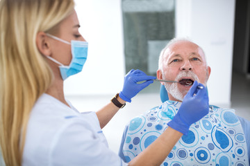 A young female dentist controls the health of the tooth