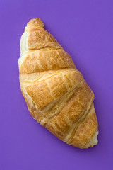 Croissant on violet background. Top view


