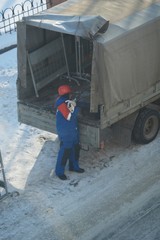 Worker in the form of snow goes to the car  