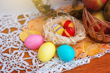 Easter still life: a wreath of vines, fruit basket, cake and eggs.