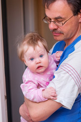 Father holding baby in her arms.