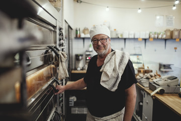 Portrait of baker next to oven