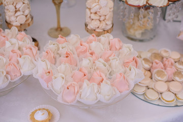 Dishes with delicious sweets with cream stand on the candy bar on wedding dinner